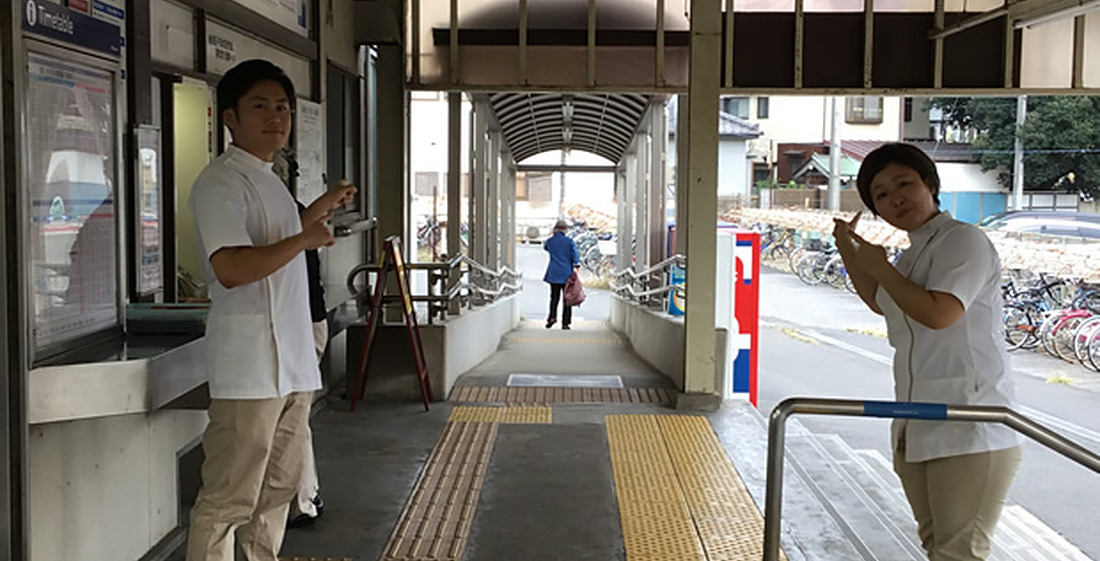京成西船駅の改札を出た通路と出口をご案内するスタッフ