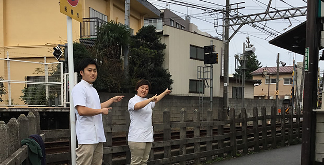 踏切の手前まで続く道をご案内するスタッフ